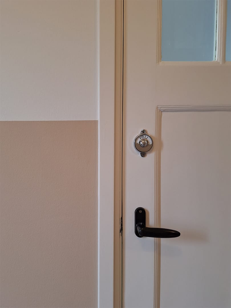 detail lakwerk op een deur met een scherpe lijn langs de muur.